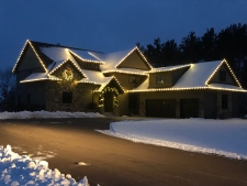 Snow-covered roof with yellow bulb lights around perimeter