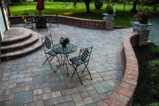 Circular patio with rectangle stones and short brick wall