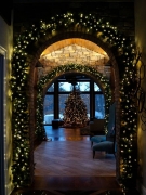 Arched interior doorway of house outlined in lit wreathdecorative holiday garland in Lake Elmo, MN.