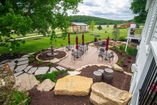 Paver patio with limestone retaining walls and mulch beds